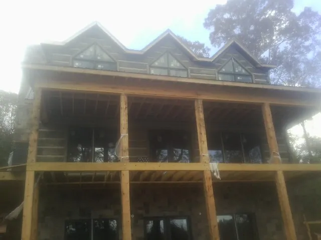Dormers and porch framing on a large log home under construction — Roof Coating work by our crew in Flagstaff