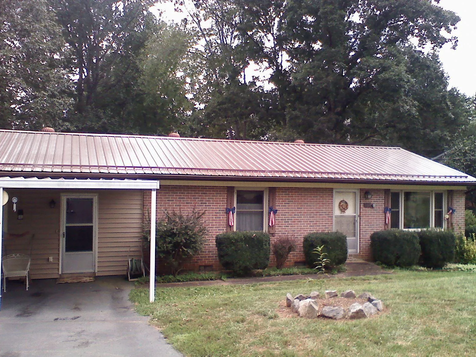 Bronze metal roof and carport on a brick ranch home — Roof Repair work by our crew in Flagstaff